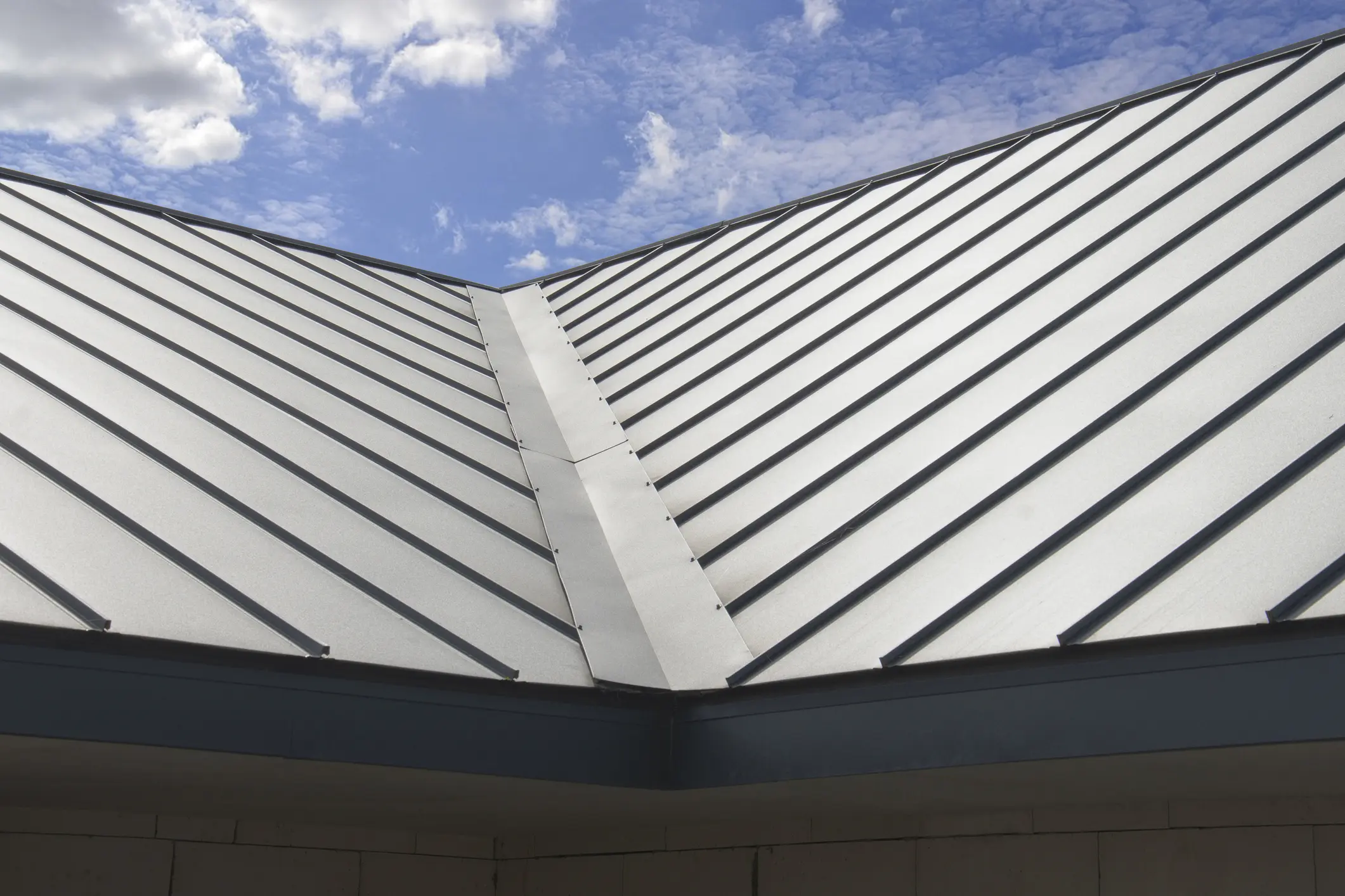 Steel roof panels and clouds above