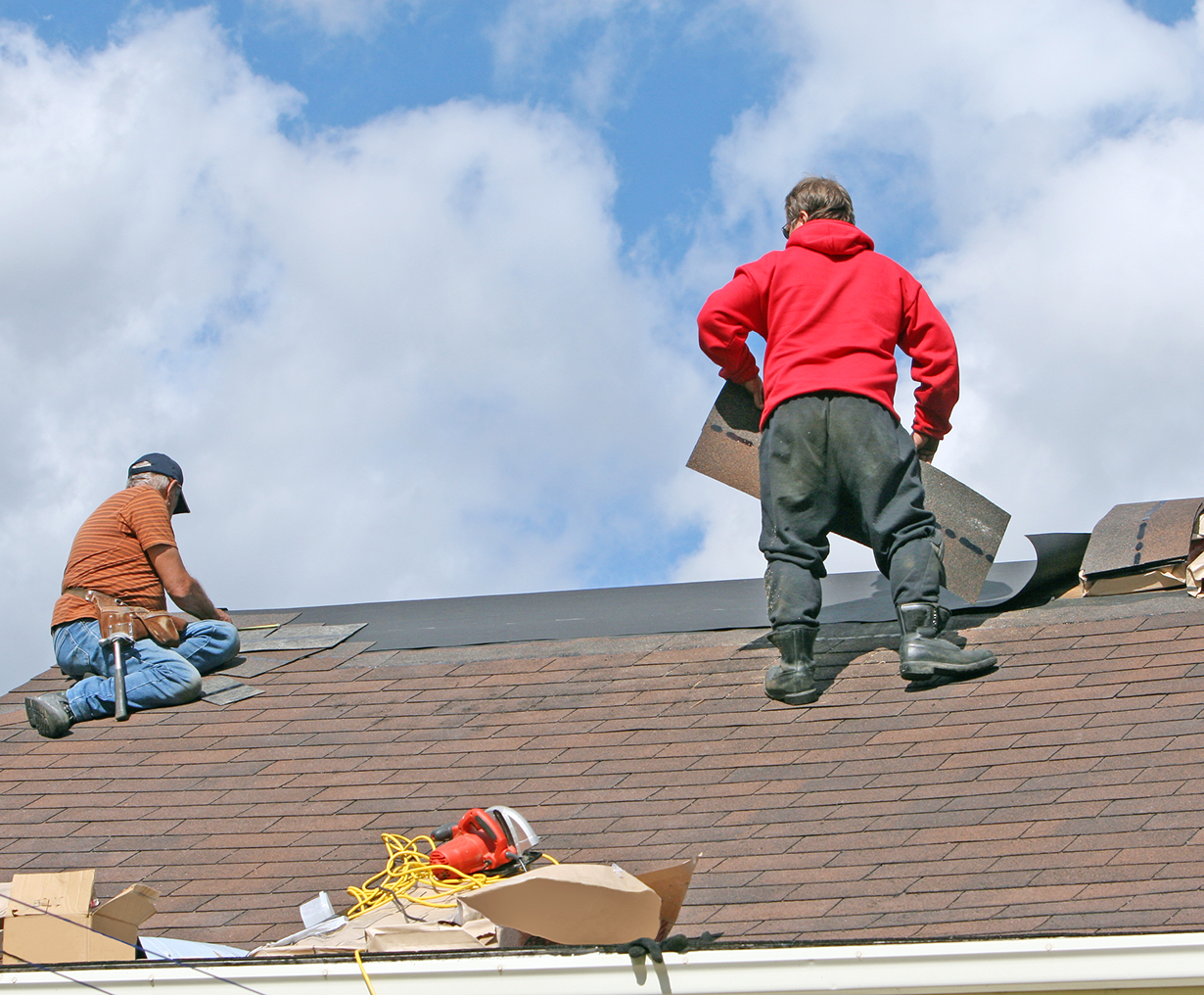 Roofers working on shingled roof