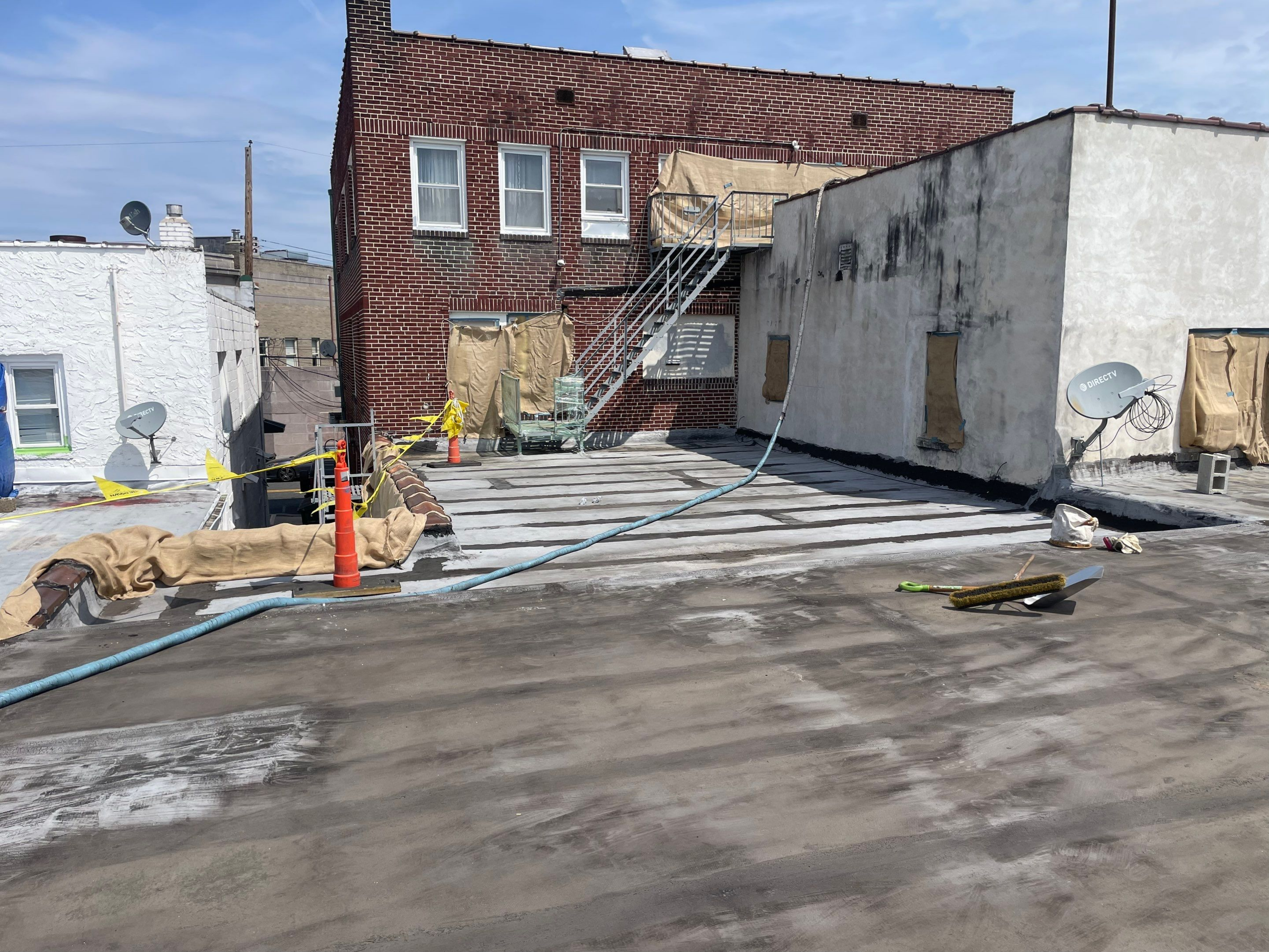 Urban rooftop under repair with construction materials scattered.
